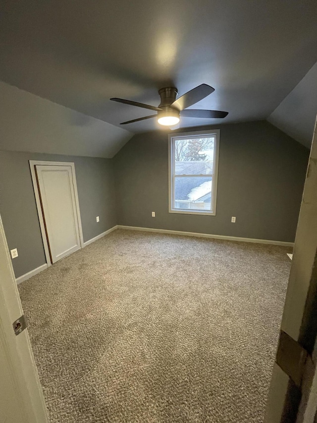 additional living space featuring carpet flooring, vaulted ceiling, and ceiling fan