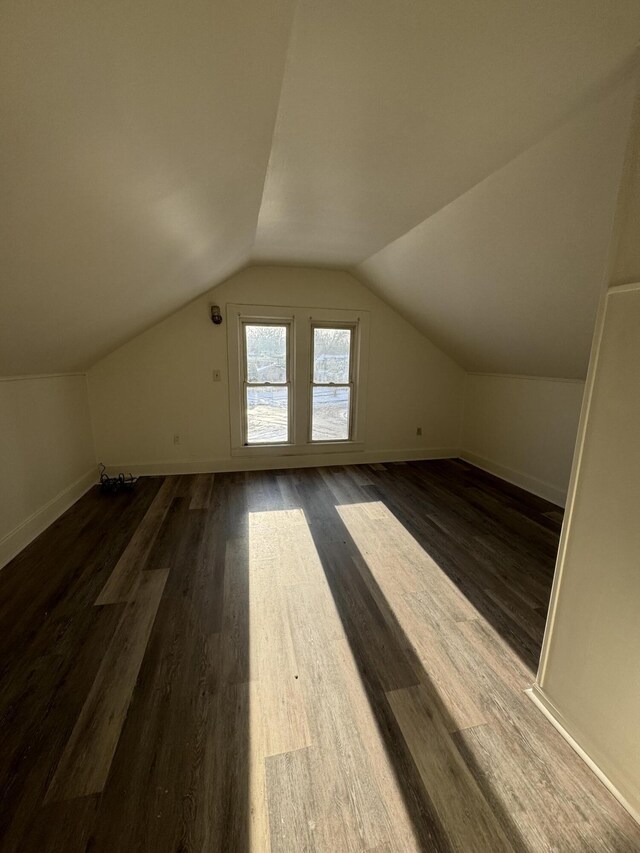 additional living space featuring vaulted ceiling and dark hardwood / wood-style floors