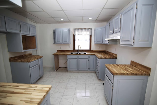 kitchen with wooden counters, gray cabinets, and sink