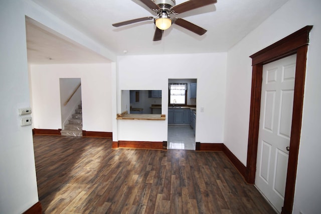 unfurnished living room with ceiling fan, sink, and dark hardwood / wood-style floors