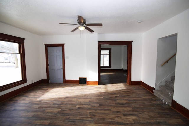 empty room featuring dark hardwood / wood-style flooring, ceiling fan, and plenty of natural light