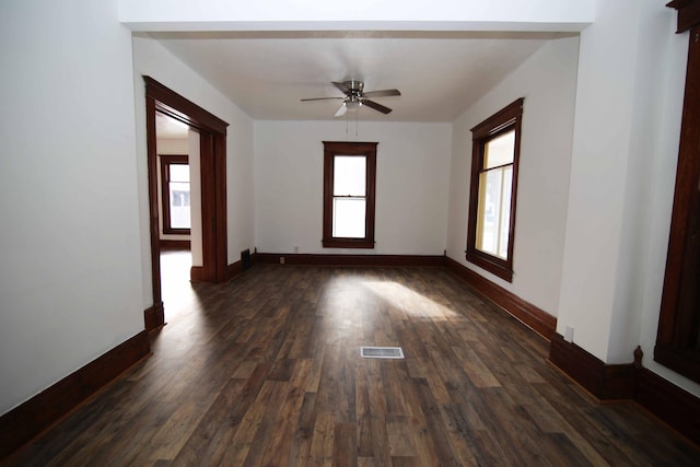 empty room with ceiling fan and dark hardwood / wood-style flooring