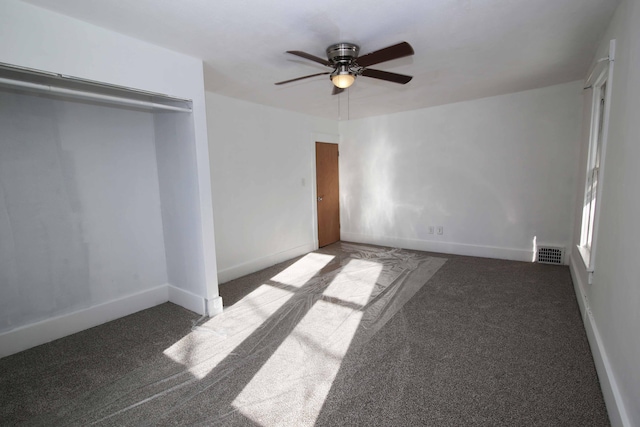 unfurnished bedroom featuring ceiling fan and dark carpet