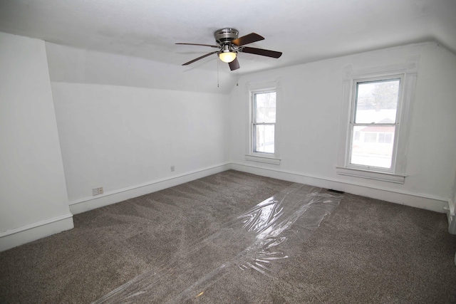 carpeted empty room featuring vaulted ceiling, a wealth of natural light, and ceiling fan