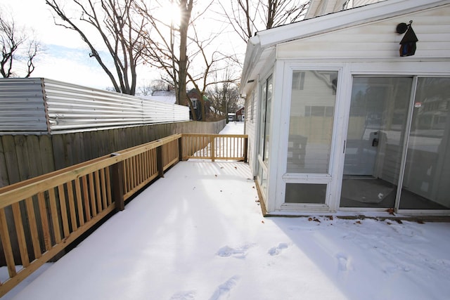 snow covered patio with a wooden deck