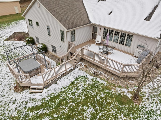 snow covered property featuring a covered hot tub and a wooden deck