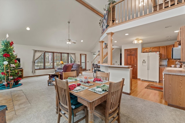 dining area featuring high vaulted ceiling, ceiling fan, light wood-type flooring, beam ceiling, and decorative columns