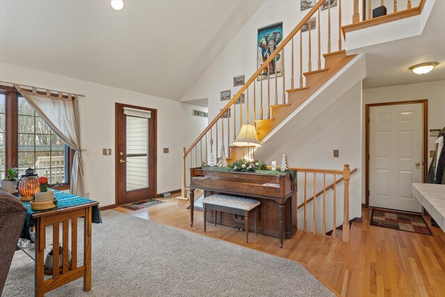 foyer entrance with lofted ceiling and light wood-type flooring