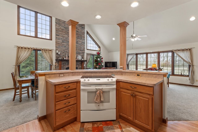 kitchen with white range with electric stovetop, ceiling fan, light wood-type flooring, and ornate columns