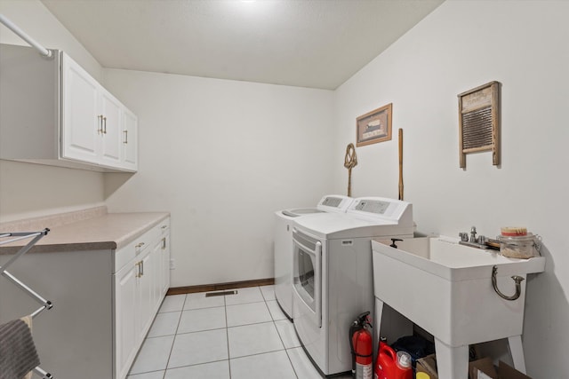 washroom featuring light tile patterned flooring, cabinets, independent washer and dryer, and sink