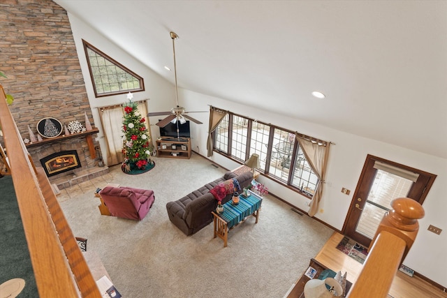 carpeted living room featuring ceiling fan, a fireplace, and high vaulted ceiling