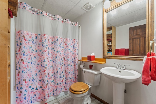 bathroom with tile patterned floors, a shower with shower curtain, and toilet