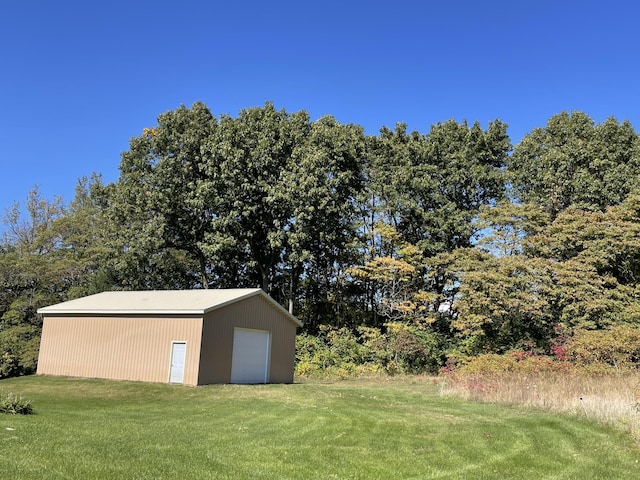 view of yard featuring a garage and an outbuilding