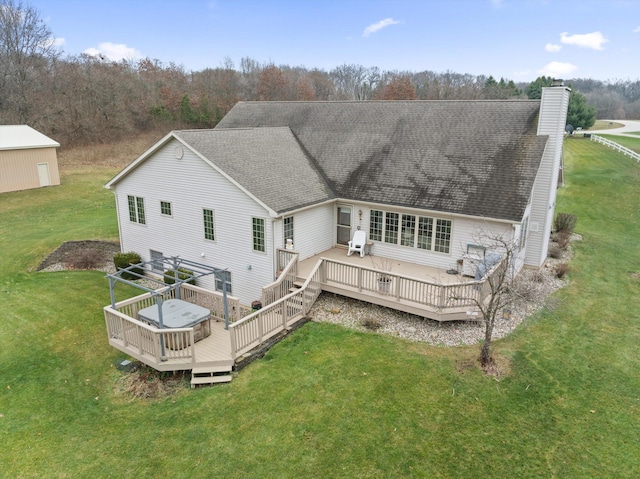 rear view of house with a yard and a wooden deck