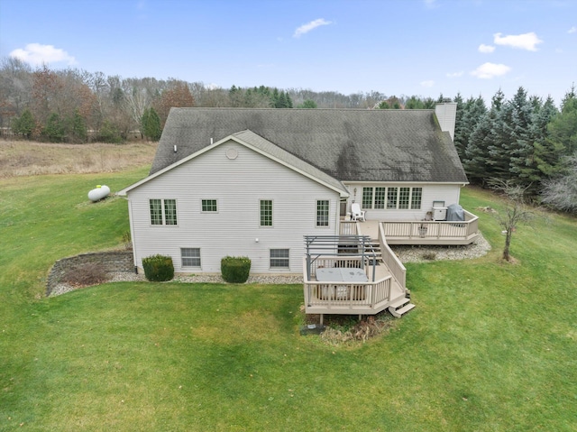 rear view of property featuring a wooden deck and a yard