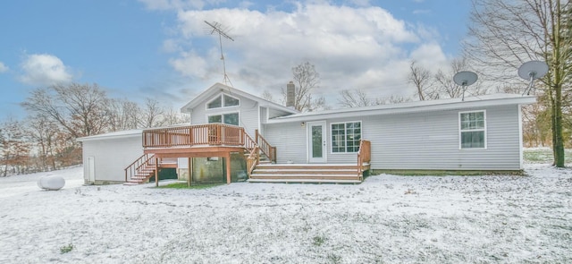 snow covered house featuring a wooden deck