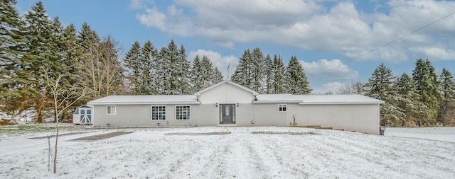 snow covered property featuring a shed