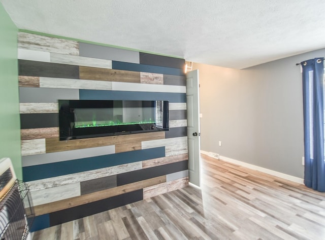 interior space with hardwood / wood-style flooring, a textured ceiling, and heating unit