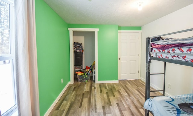 bedroom with wood-type flooring and a textured ceiling