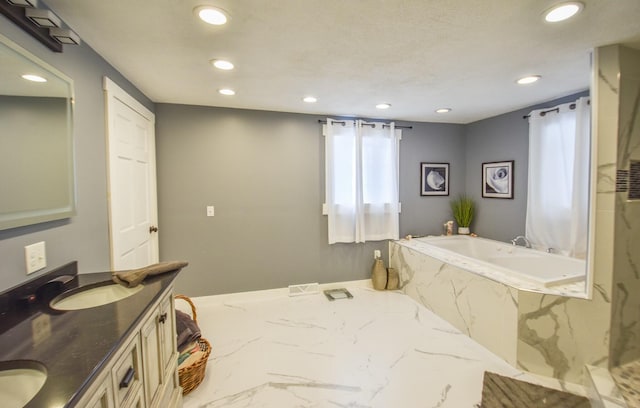 bathroom with vanity and tiled bath