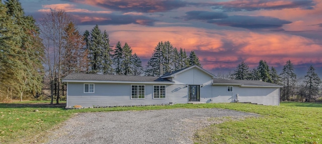 ranch-style house with gravel driveway and a front lawn