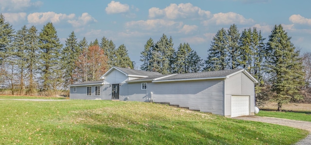 view of front of property featuring an attached garage, dirt driveway, and a front yard