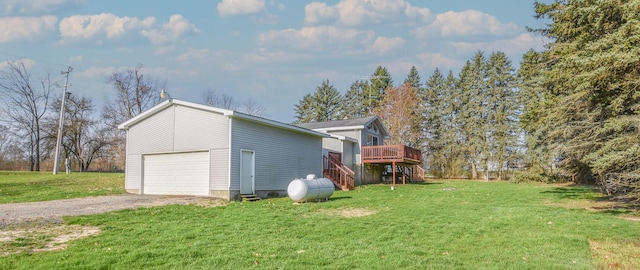 view of side of home with dirt driveway, a lawn, stairway, and a deck