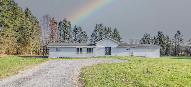 single story home featuring gravel driveway and a front yard