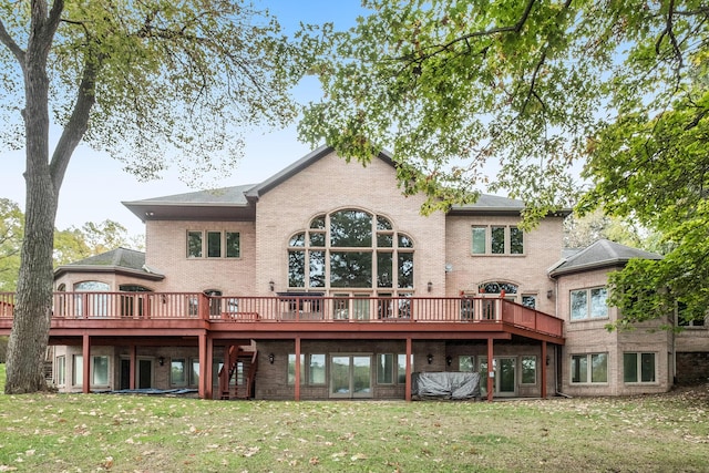 rear view of property featuring a wooden deck and a yard