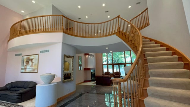 stairway featuring a towering ceiling