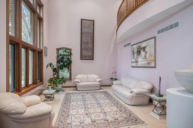 tiled living room featuring a towering ceiling