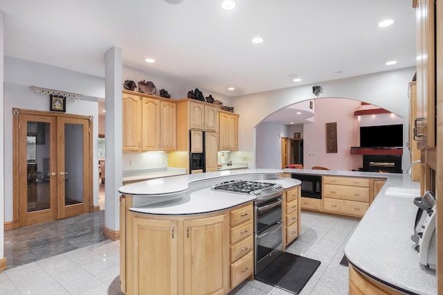 kitchen with kitchen peninsula, light brown cabinets, built in appliances, and sink