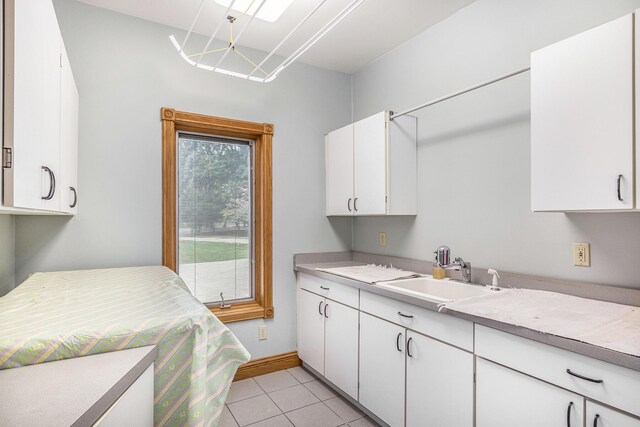 laundry area with light tile patterned flooring and sink