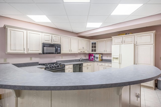 kitchen featuring black appliances, a kitchen bar, and kitchen peninsula