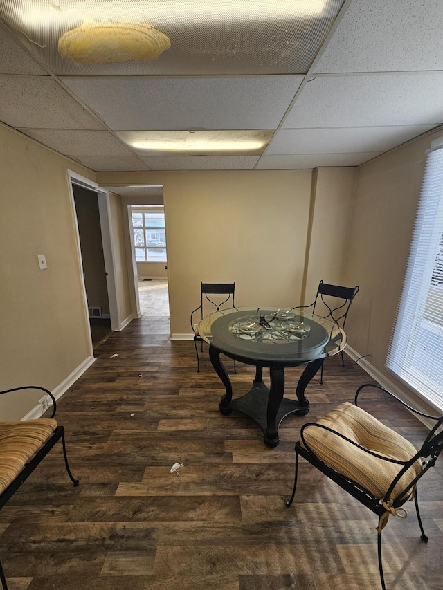 dining room featuring a paneled ceiling and dark hardwood / wood-style floors