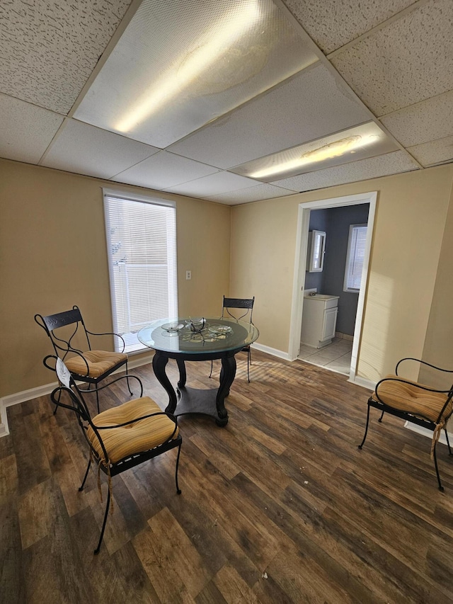 dining room with hardwood / wood-style floors and a drop ceiling