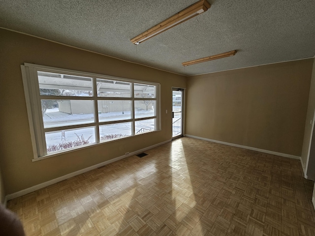 empty room featuring parquet flooring and a textured ceiling