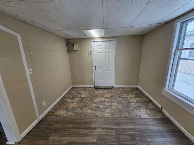 interior space with a paneled ceiling and dark wood-type flooring