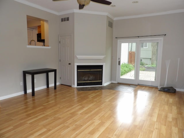 unfurnished living room featuring ceiling fan, crown molding, and light hardwood / wood-style floors