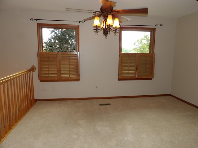 empty room featuring carpet flooring, ceiling fan, and a healthy amount of sunlight