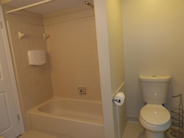 bathroom with tile patterned floors, tiled shower / bath combo, and toilet