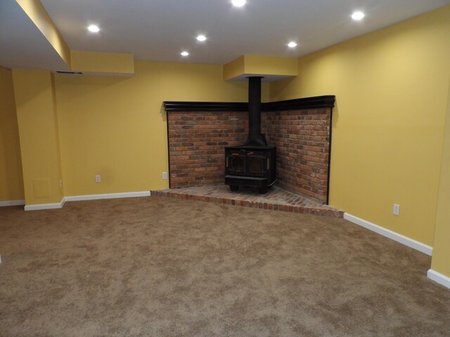 unfurnished living room with a wood stove and carpet floors