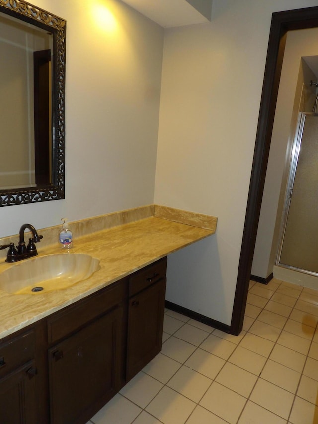 bathroom with vanity, tile patterned floors, and a shower with door