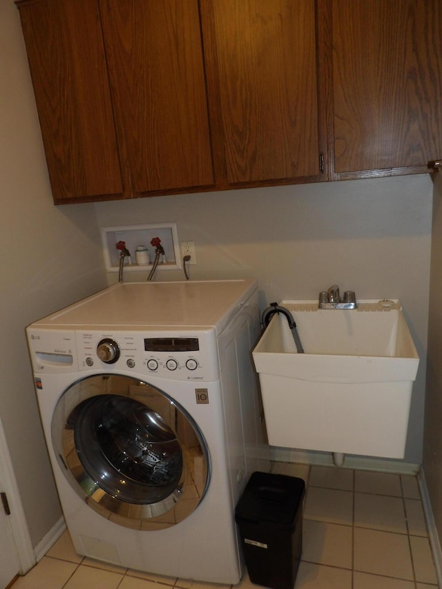 laundry room with cabinets, washer / dryer, light tile patterned floors, and sink