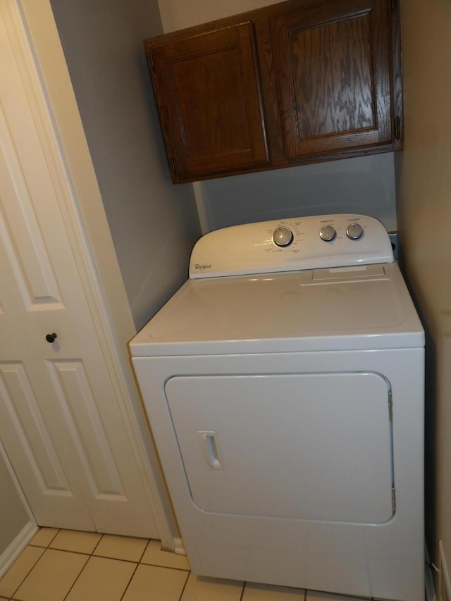 washroom featuring washer / clothes dryer, light tile patterned floors, and cabinets