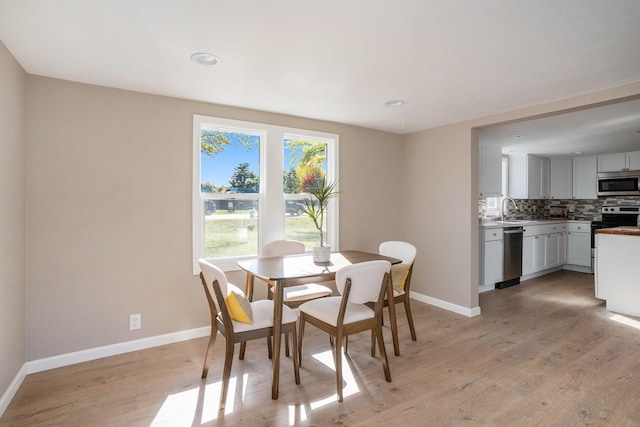 dining space featuring sink and light hardwood / wood-style floors