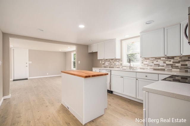 kitchen with sink, white cabinets, and wood counters