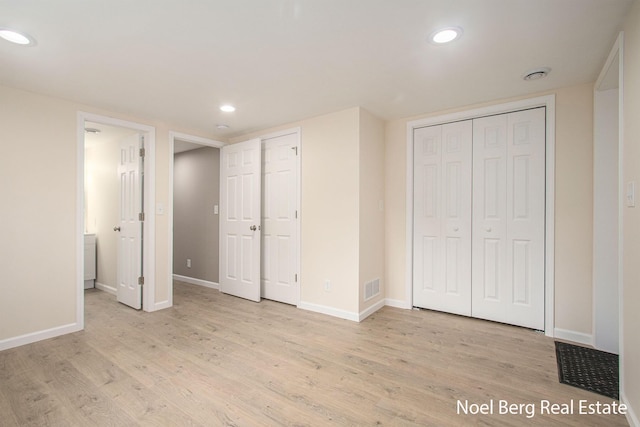 unfurnished bedroom with ensuite bath and light wood-type flooring