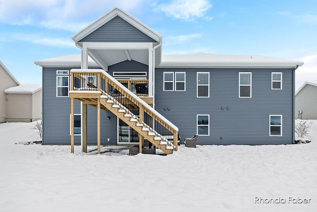 snow covered house with a deck