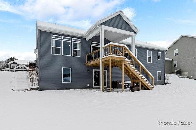 snow covered property featuring a wooden deck